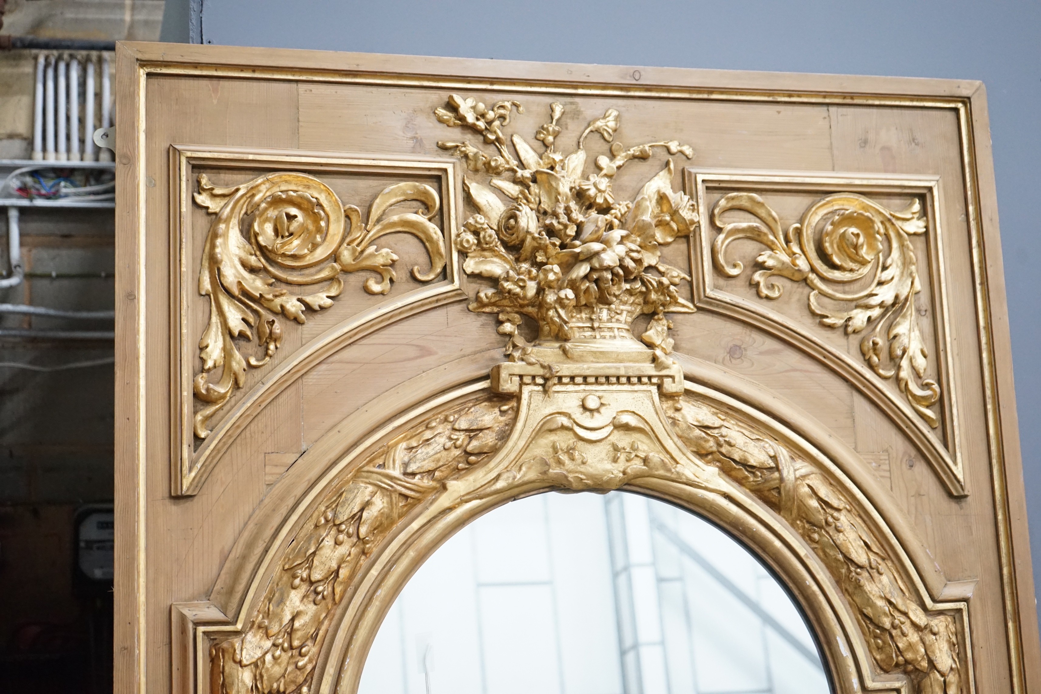 A Victorian pitch pine and gilt composition wall mirror the arched plate with floral vase surmount, width 117cm, height 212cm